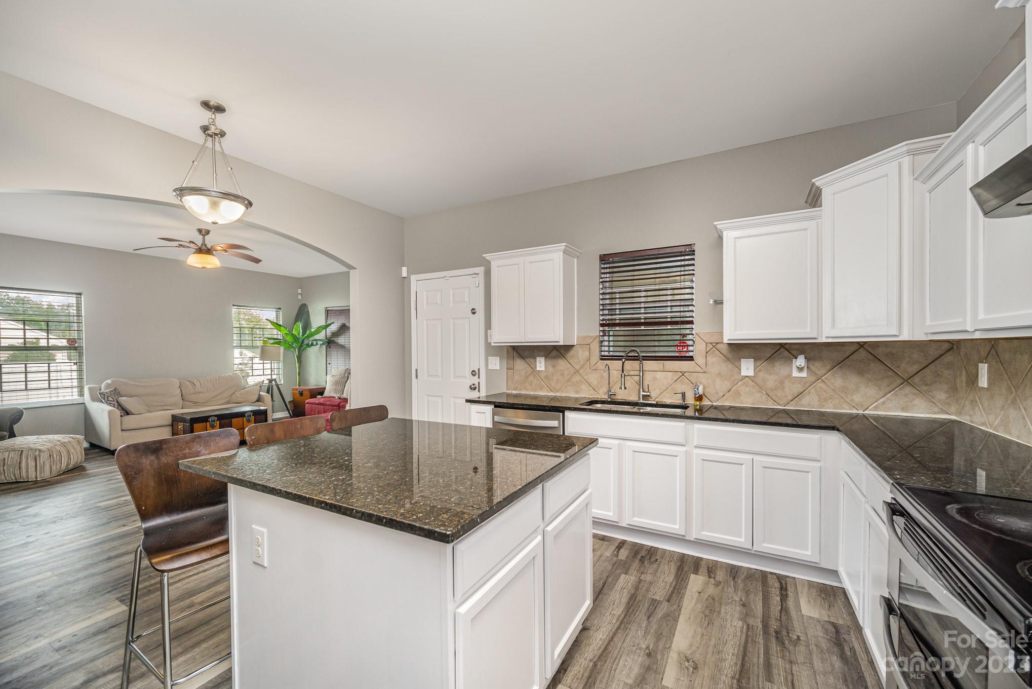 175 Old Carriage Road Clover, SC 29710 - Photo 13 of 34 a kitchen with stainless steel appliances granite countertop a sink stove oven and white cabinets with wooden floor