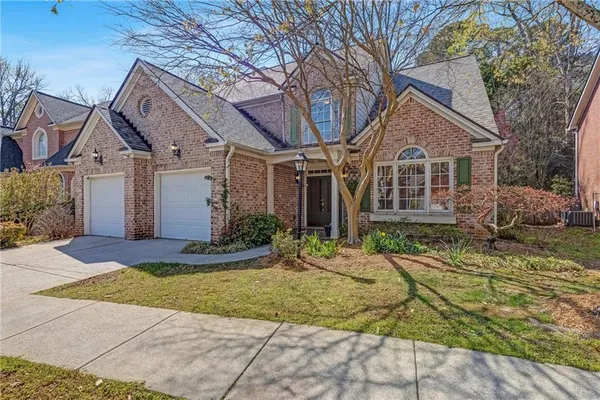 a view of a white house with large windows and a small yard