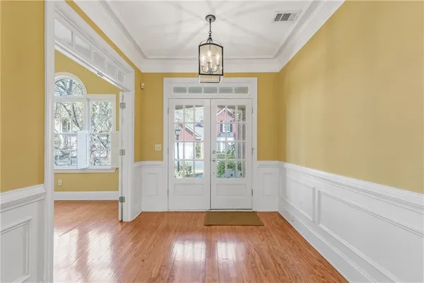 a view of a room with a chandelier fan and wooden floor
