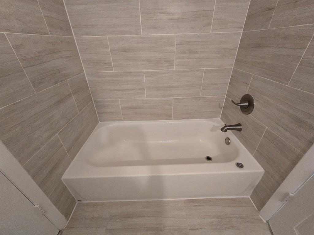 8657 Southwest 5th Street, Unit 201 Pembroke Pines, FL 33025 - Photo 8 of 15 a bathroom with a white bath tub