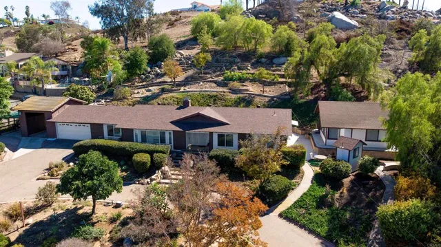 an aerial view of a house with a yard and outdoor seating