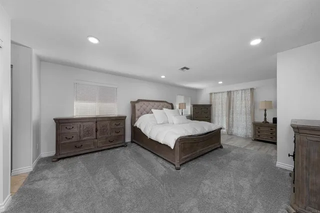 a spacious bedroom with a bed and a cabinets