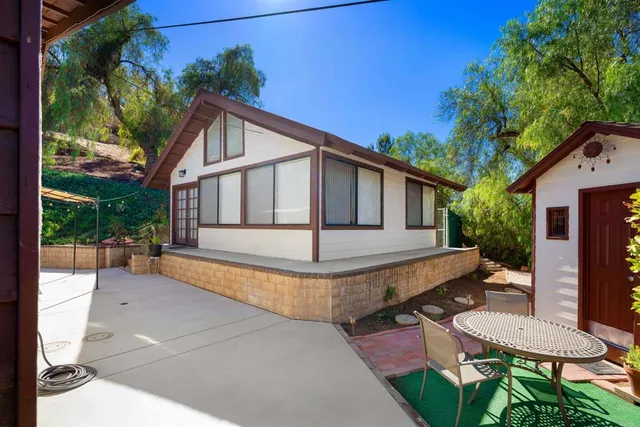 a view of a house with backyard and sitting area