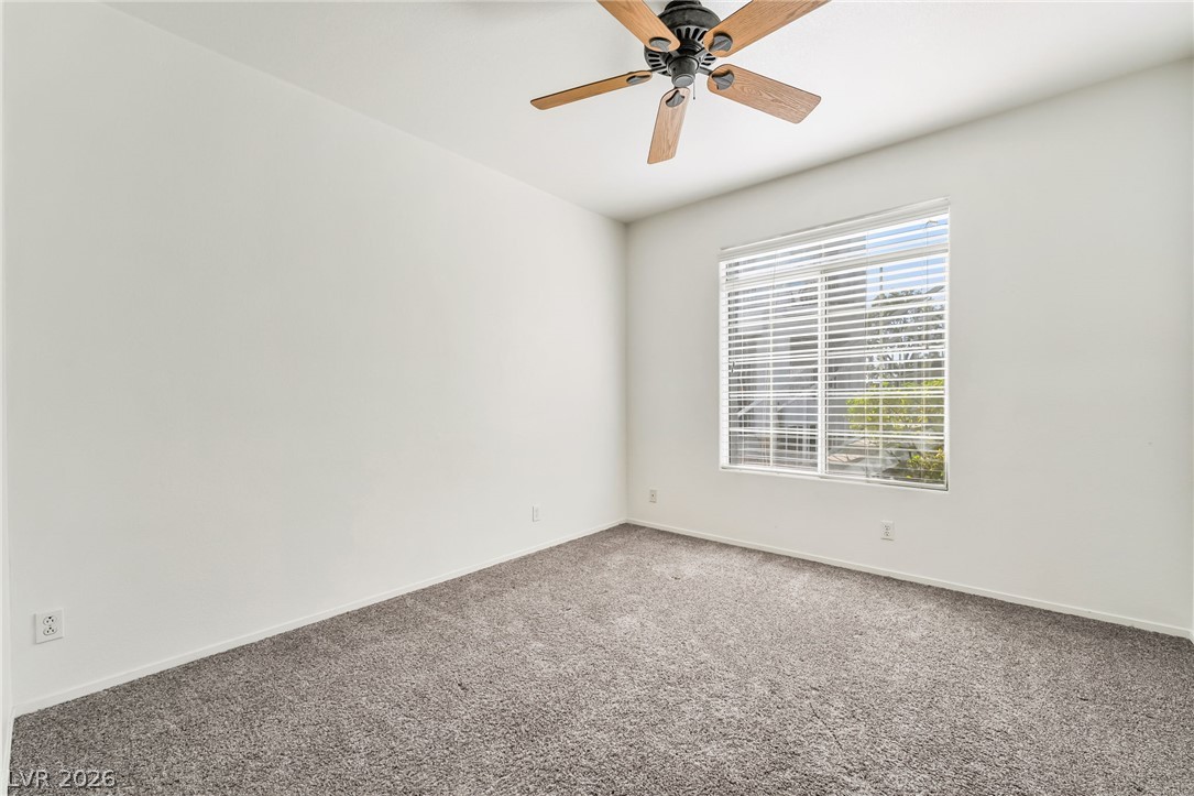 2201 Ramsgate Drive, Unit 811 Henderson, NV 89074 - Photo 19 of 36 A quiet bedroom offers plush carpet and a ceiling fan, ready for personal touches.