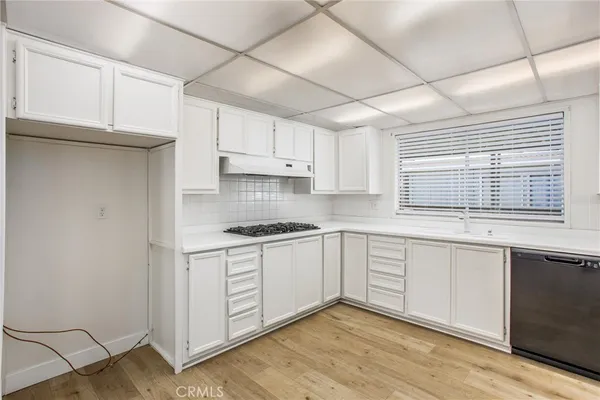 a kitchen with stainless steel appliances granite countertop a stove a sink and white cabinets