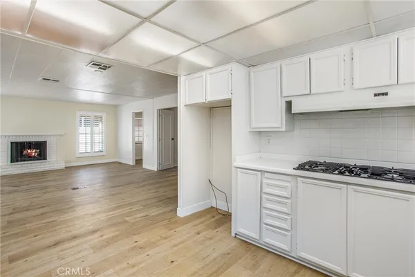 a kitchen with cabinets and wooden floor