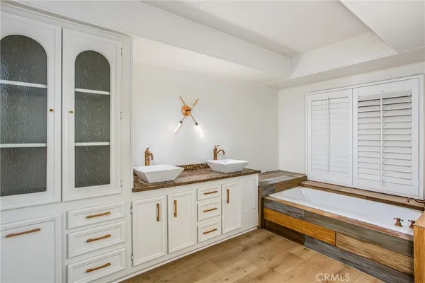a bathroom with a granite countertop sink and a window