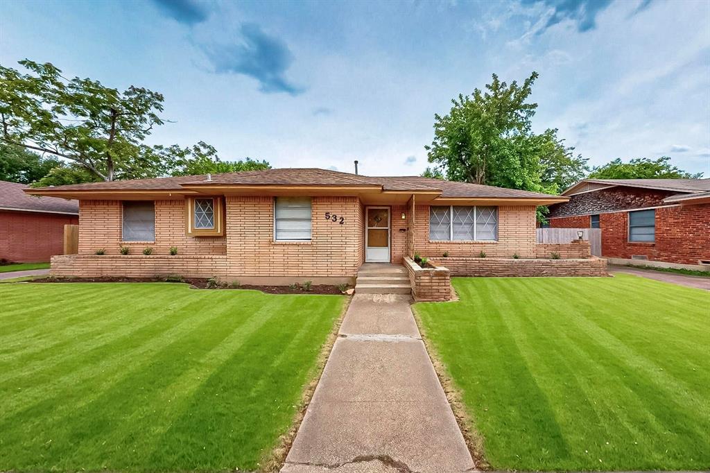 a front view of a house with yard patio and green space