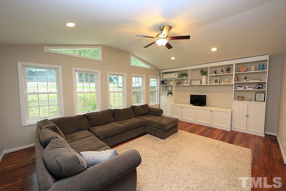 6004 Spring Valley Drive Raleigh, NC 27616 - Photo 10 of 25 Light and bright large sunroom addition (permitted) that has great bookshelf storage.