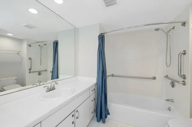 a bathroom with a tub sink mirror and a shower