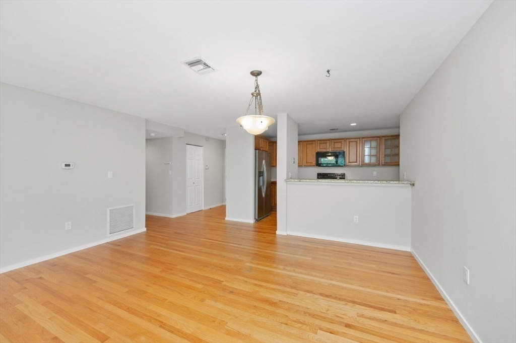 183 Oak Street, Unit 307 Newton, MA 02464 - Photo 8 of 24 a view of a kitchen with granite countertop cabinets and wooden floor