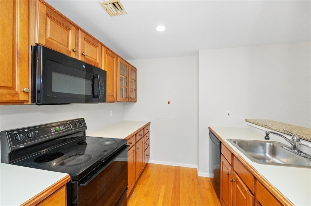 183 Oak Street, Unit 307 Newton, MA 02464 - Photo 9 of 24 a kitchen with stainless steel appliances a stove a microwave and sink