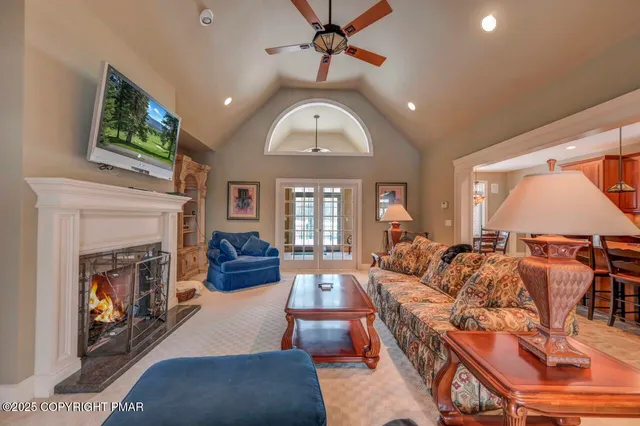 a dining hall with stainless steel appliances kitchen island granite countertop a table chairs and a chandelier