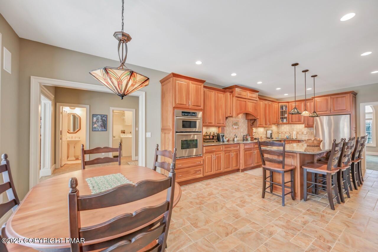 235 Wolf Hollow Road Lake Harmony, PA 18624 - Photo 23 of 96 a dining hall with stainless steel appliances kitchen island granite countertop a table chairs and a chandelier