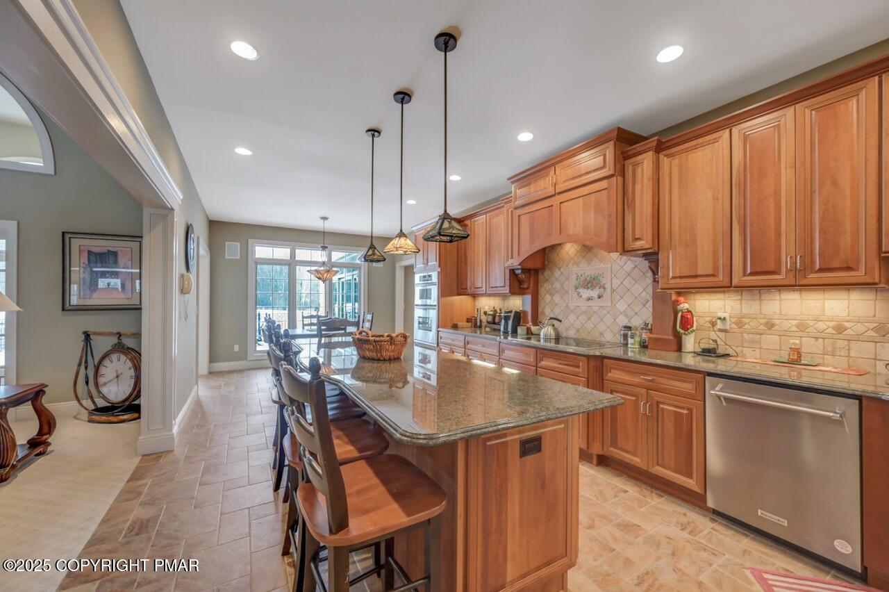 235 Wolf Hollow Road Lake Harmony, PA 18624 - Photo 30 of 98 a open kitchen with stainless steel appliances granite countertop a stove top oven a sink dishwasher a dining table and chairs with wooden floor