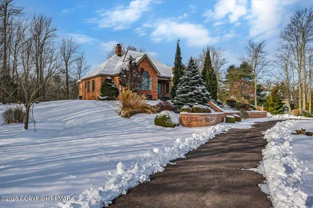a front view of house with yard and trees around