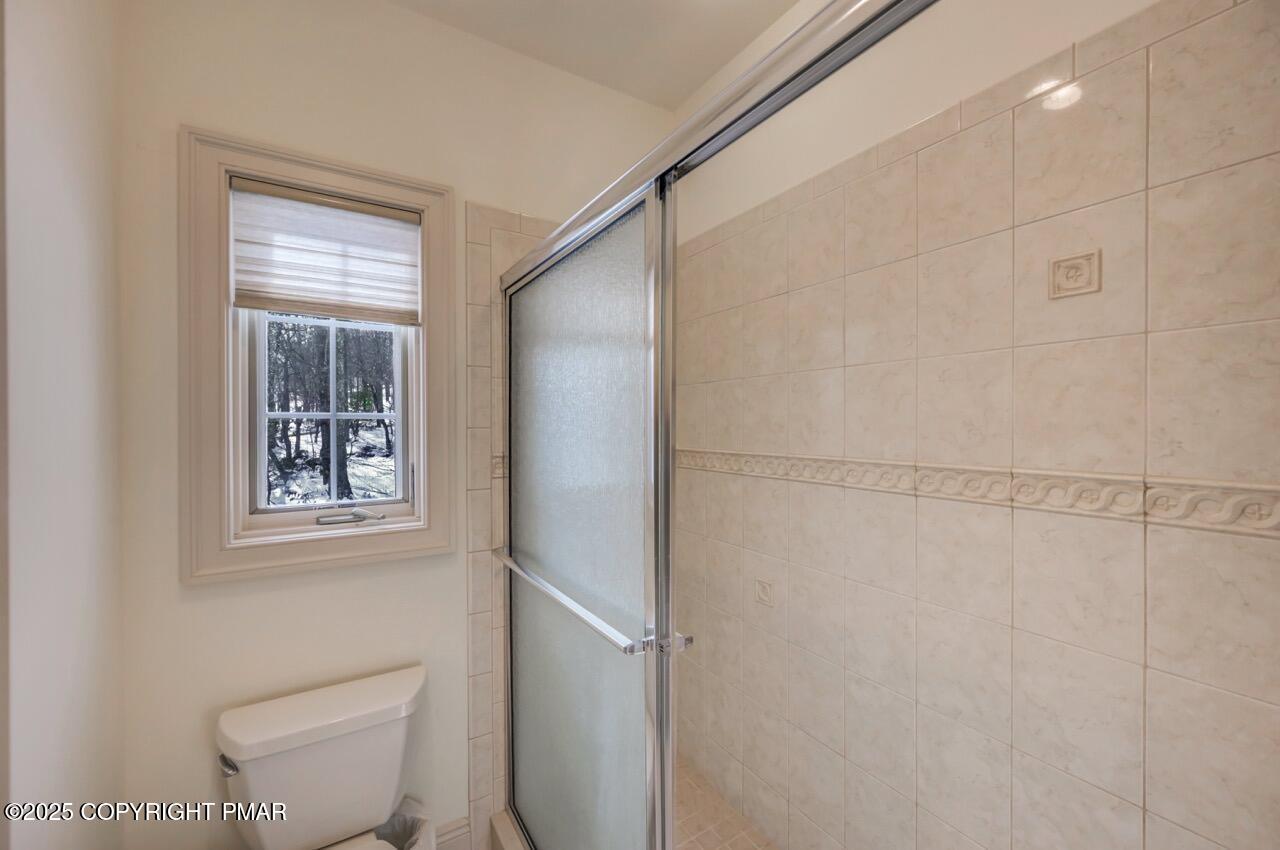 235 Wolf Hollow Road Lake Harmony, PA 18624 - Photo 72 of 96 a bathroom with a toilet and a shower curtain