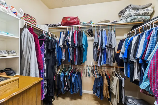 a view of walk in closet with clothes