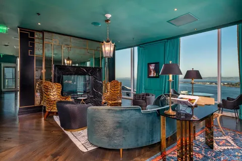 a living room with fireplace furniture and a large window