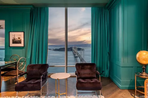 a balcony with chairs and a potted plant