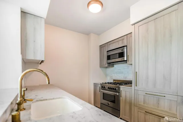 a kitchen with a sink and stainless steel appliances