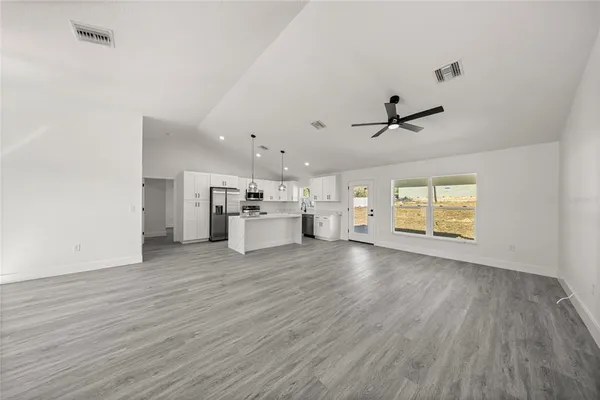 a view of empty room with wooden floor and window