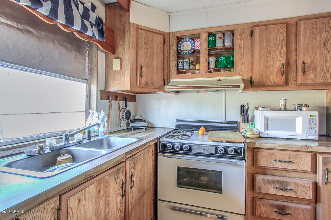 178 North Starr Road Apache Junction, AZ 85119 - Photo 36 of 41 a kitchen with stainless steel appliances granite countertop a stove a sink and a microwave