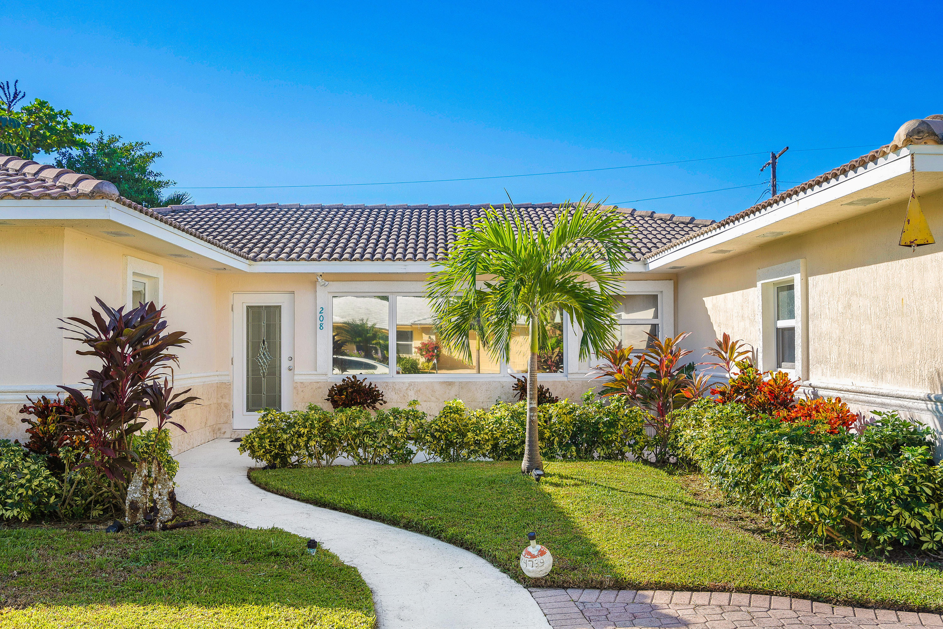 208 Bamboo Road Palm Beach Shores, FL 33404 - Photo 4 of 30 a front view of a house with a garden