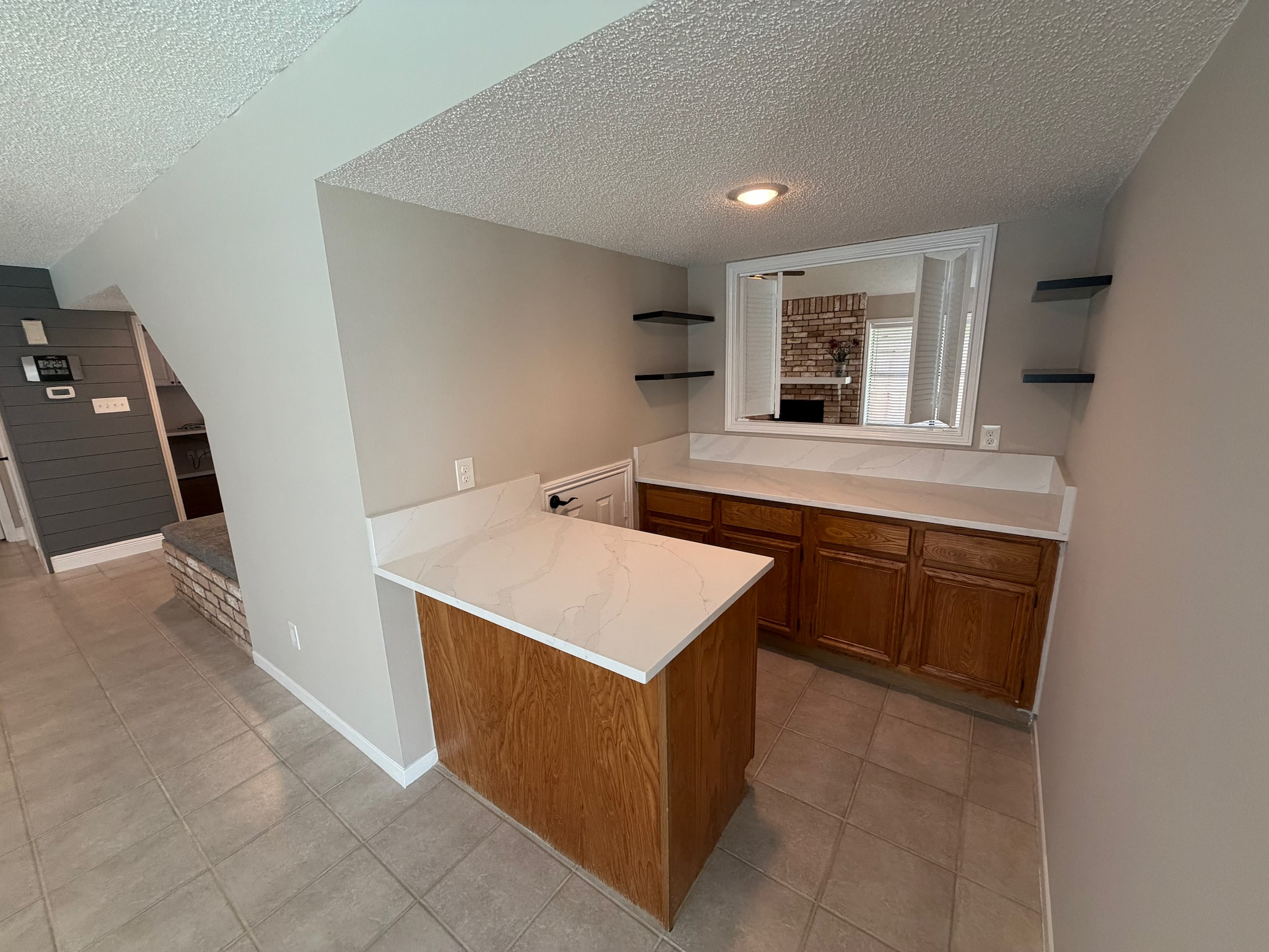 2326 Streamcrest Lane Sugar Land, TX 77479 - Photo 17 of 42 Bar area with ample cabinet storage, floating shelves, passthrough to formal living. Doorway to under stair storage area.