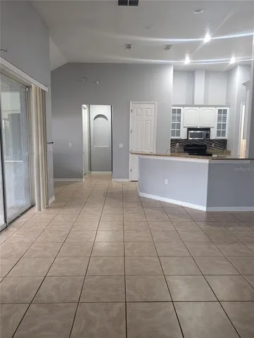 a view of a kitchen with kitchen island granite countertop a rug and a view of living room