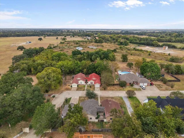 an aerial view of residential houses with outdoor space and ocean