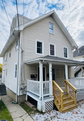 a view of a house with a small deck and a floor to ceiling window