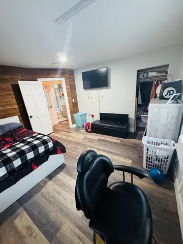 a view of a hallway with wooden floor and closet