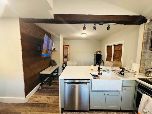 a room with a washing machine with wooden floor