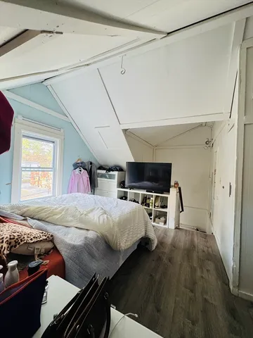 a bed room with a bed furniture and a flat tv screen