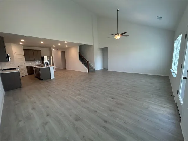 an empty room with a ceiling fan and a fan