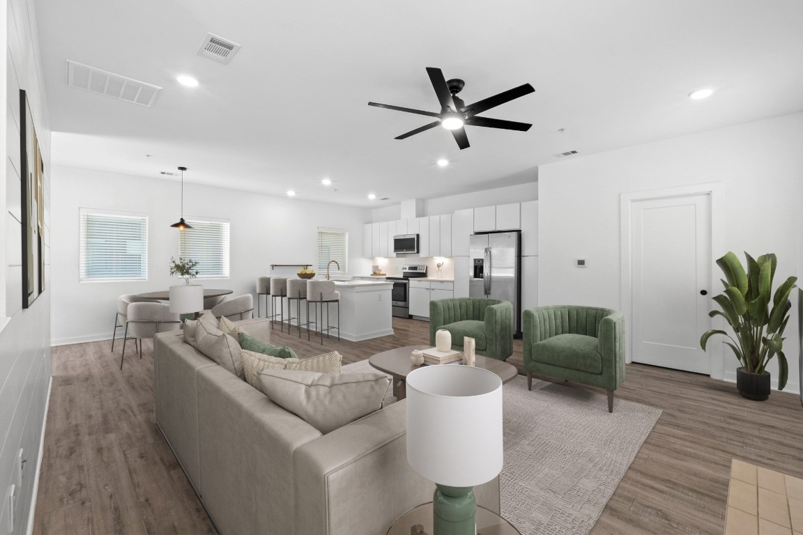 a living room with furniture kitchen view and a potted plant