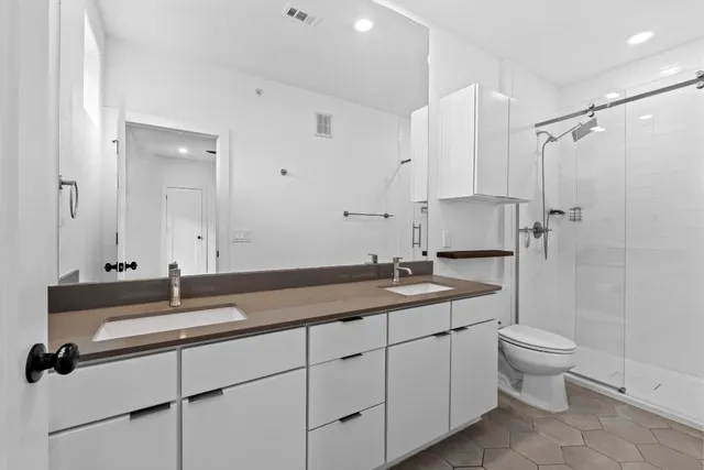a bathroom with a granite countertop sink a toilet and a mirror