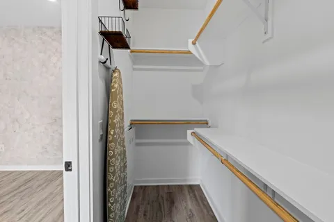 a view of walk in closet with wooden floor