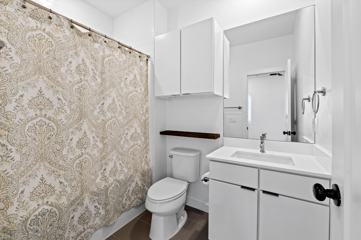 5924 South Congress Avenue, Unit 114S Austin, TX 78745 - Photo 20 of 24 a bathroom with a sink a toilet and a mirror