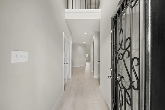 a view of a hallway with wooden floor and a door