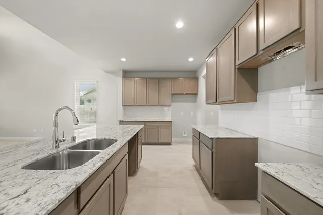 a kitchen with a sink a counter top space stainless steel appliances and cabinets