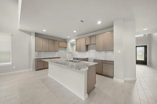 a large kitchen with kitchen island a sink stainless steel appliances and cabinets