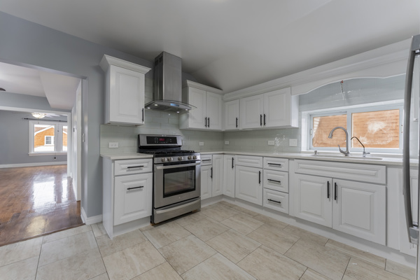 1215 North Harding Avenue, Unit 2 Chicago, IL 60651 - Photo 9 of 10 a kitchen with granite countertop white cabinets and stainless steel appliances