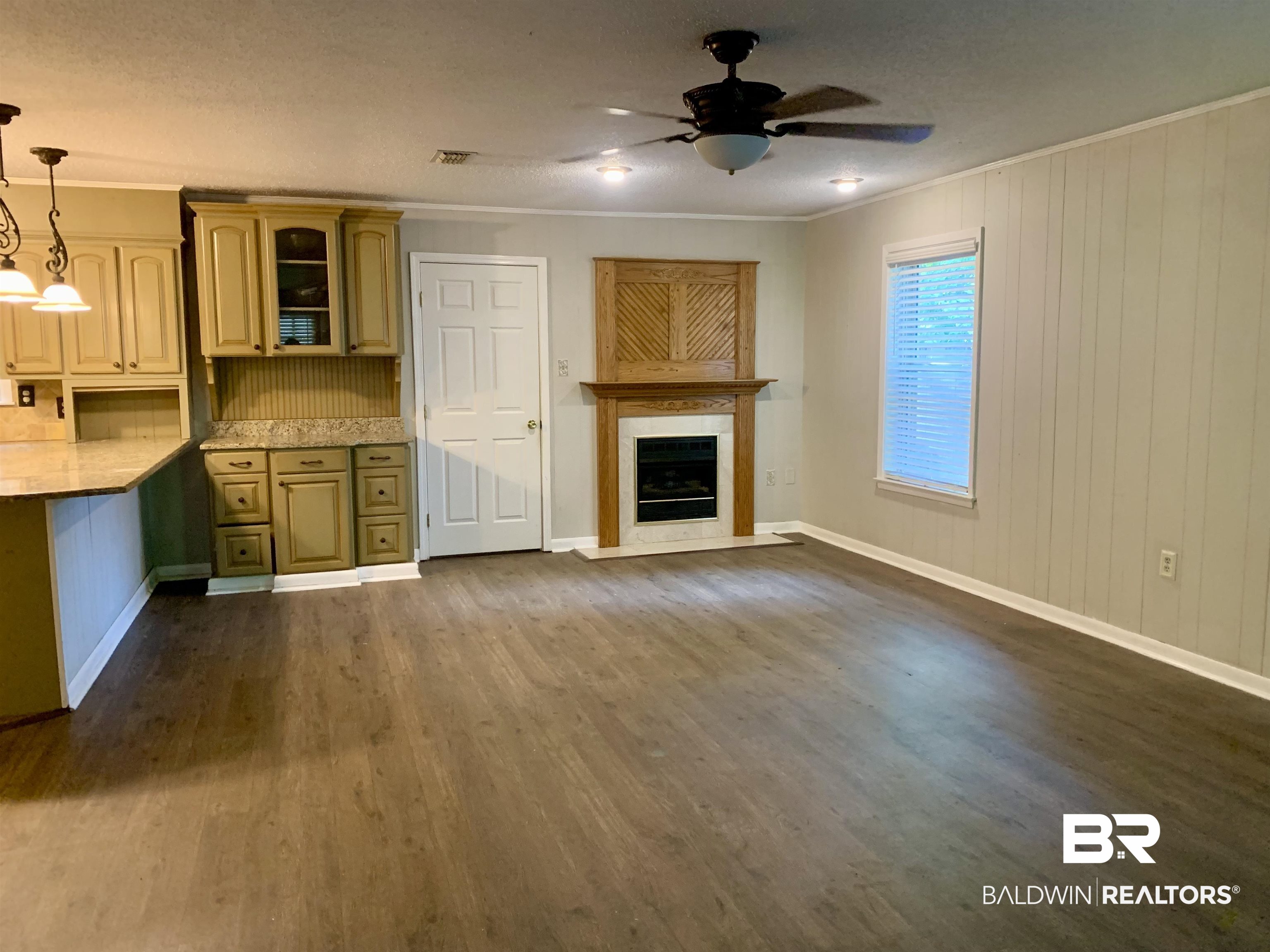 2708 E Road Mobile, AL 36693 - Photo 2 of 12 Unfurnished living room with dark hardwood / wood-style floors, ornamental molding, and ceiling fan