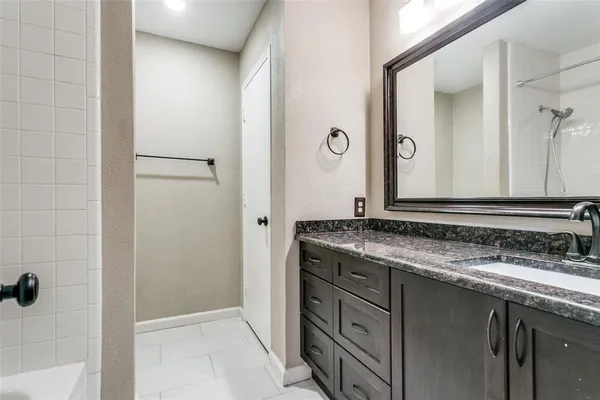 a bathroom with a granite countertop sink and a mirror