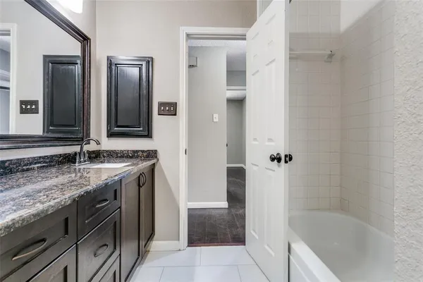 a bathroom with a granite countertop sink and mirror