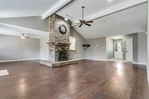 a view of an empty room with a window and fireplace