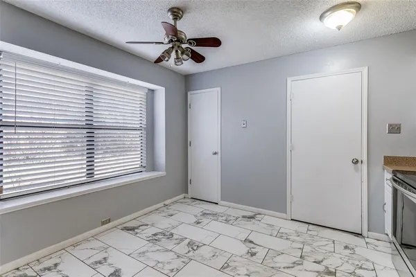 a view of a livingroom with a chandelier fan and windows