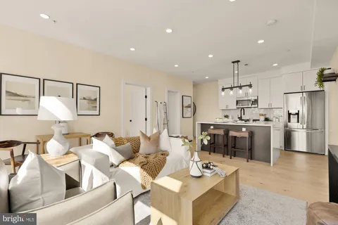 a living room with stainless steel appliances kitchen island granite countertop furniture and a view of kitchen